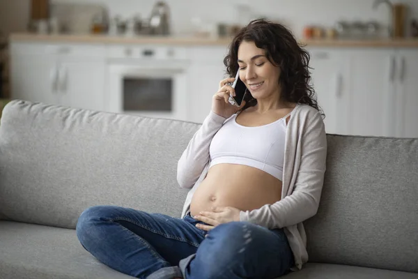 Lachende Zwangere Vrouw Praten Mobiele Telefoon Strelen Haar Buik Terwijl — Stockfoto