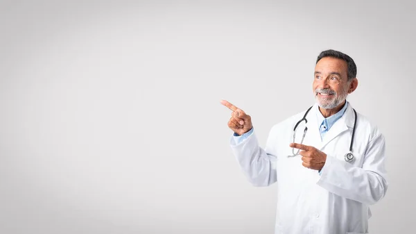 Médico Velho Europeu Amigável Feliz Casaco Branco Com Estetoscópio Aponta — Fotografia de Stock
