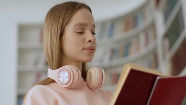 Zanurzone Literackich Poszukiwaniach Close Portret Młodej Zamyślonej Studentki Słuchawkami Szyi — Wideo stockowe