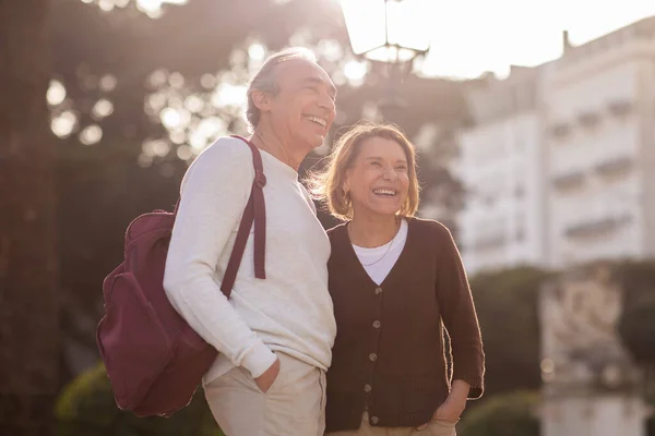 Joyful Senior Couple Backpack Embracing Posing European Residential Building Outdoor — Stock Photo, Image