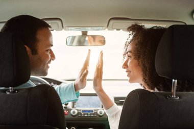 Yeni araba. Neşeli Orta Doğulu Genç Eşler Birlikte Lüks Otomobillerinde Oturarak Çak Beşlik Veriyorlar. Başarılı Araç Kiralama Anlaşması. Arka Görünüm Görüntüsü