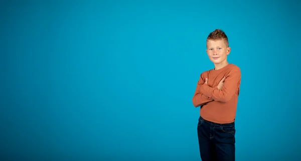 Reklamınız Için Mavi Arkaplanda Kollarını Kıvırmış Gülümseyen Beyaz Bir Oğlanla — Stok fotoğraf