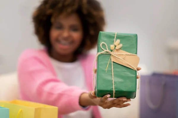 Podekscytowana Młoda Czarna Kobieta Siedzi Kanapie Salonie Trzymając Zielony Karton — Zdjęcie stockowe