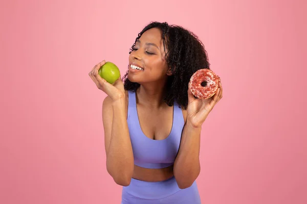 Alegre Pensativa Dama Afroamericana Milenaria Ropa Deportiva Elige Donut Manzana — Foto de Stock