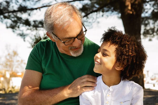 Cheerful Senior Caucasian Grandfather Hugging Little Mixed Race Boy Talking — Stock Photo, Image
