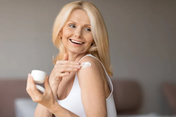 Θρεπτικό Δέρμα Ενθουσιασμένη Όμορφη Ηλικιωμένη Γυναίκα Που Εφαρμόζει Ενυδατική Κρέμα — Φωτογραφία Αρχείου