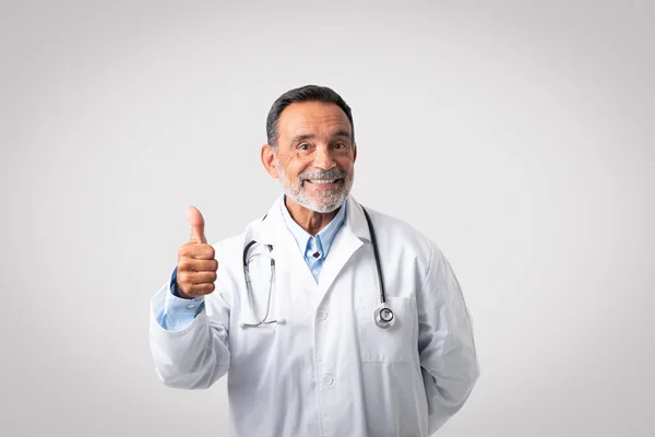 Sorrindo Europeu Médico Sênior Casaco Branco Mostrar Polegar Fundo Cinza — Fotografia de Stock