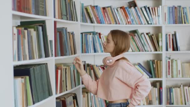 Hagyományos Tudásforrás Fiatal Pozitív Diák Keres Könyvet Könyvespolcokon Könyvtárban Felkészülés — Stock videók