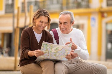 Yaşlanmaz Gezgin Şehveti. Gülümseyen Son Sınıf Çifti, Turistik Haritalarını Tutuyor Yaz Tatillerini Planlıyor ve Seyahat İstikametini Seçiyor Dışarıda Oturuyor. Gezginler Gezgin Eşleri Gezinti için Kağıt Harita Kullanıyor