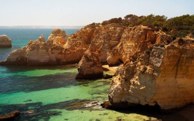 Portekiz 'in turkuvaz suyuyla kaplı dev kayalıklarla ve ormanlarla kaplı okyanus manzarası. Atlantik Kıyısı 'nın Arkaplanı. Turizm ve Seyahat Merkezi. İnsan Yok
