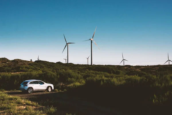Samochód Elektryczny Zaparkowany Polu Pobliżu Turbin Wiatrowych Generujących Zieloną Elekcyjność — Zdjęcie stockowe