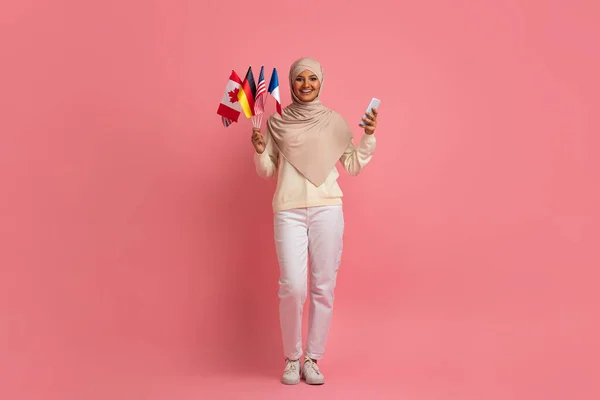 Portrait Happy Muslim Woman Holding Bunch International Flags Smartphone Smiling — Stok Foto