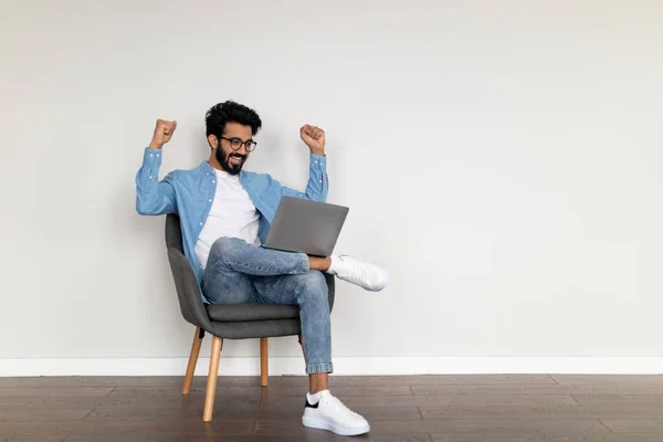 Glada Indiska Male Använda Laptop Och Skakar Knytnävar Medan Sitter — Stockfoto