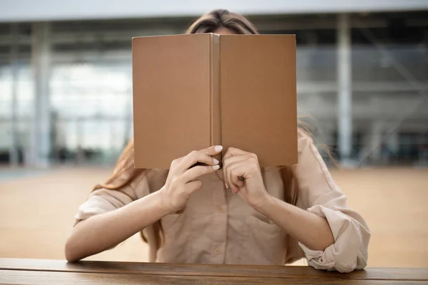Молодая Девушка Студентка Покрывает Лицо Книгой Весело Чтение Университетском Кампусе — стоковое фото