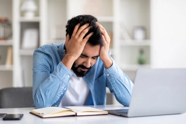 紧张的印度男性自由职业者 远程工作有问题 抑郁的船尾男人 坐在办公桌前 笔记本电脑在家里 令人垂头丧气 项目失败或头痛 — 图库照片