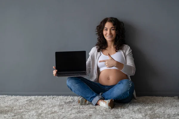 Blog Kehamilan Smiling Expectant Female Pointing Laptop Blank Black Screen — Stok Foto