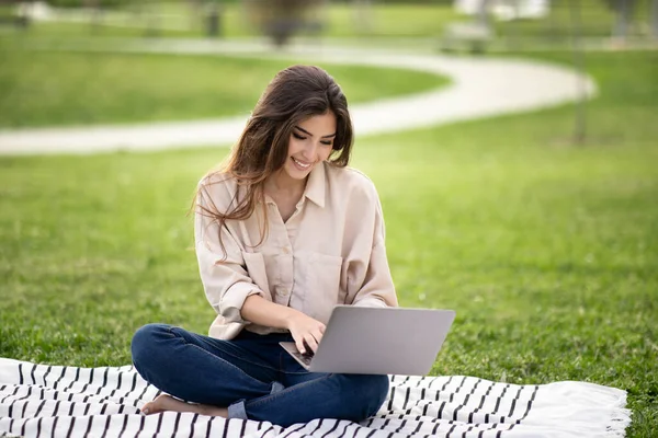 陽気な若いアジアの女性の学生のラップトップで入力し 屋外で芝生の上で再生に座る レッスンをリモートで 宿題をオンラインで 近代的な教育から休憩 技術と試験の準備 — ストック写真