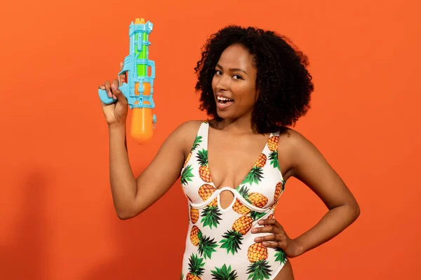 Juguetona Mujer Negra Bastante Joven Traje Baño Colorido Sosteniendo Pistola —  Fotos de Stock