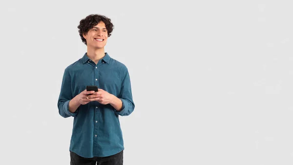 Gadgets Aanbod Happy Young Man Holding Phone Looking Aside Kopieerruimte — Stockfoto
