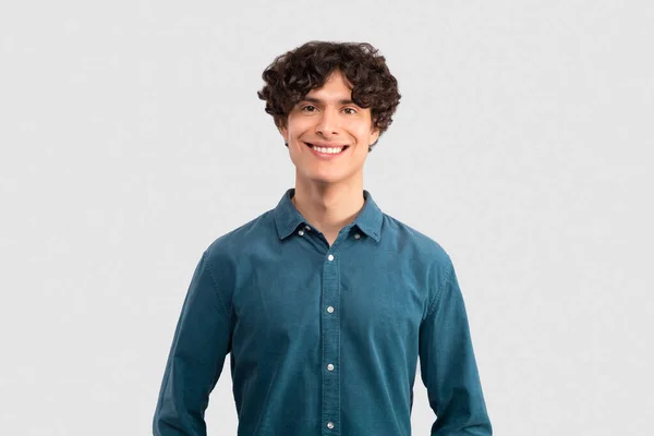 男性魅力 快乐帅气的布鲁内特年轻人在浅灰工作室背景下表现出的积极向上和自信 对着相机微笑 穿着蓝色衬衫的工作室肖像 — 图库照片
