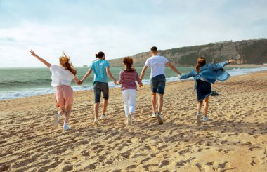 Gülümseyen bin yıllık Avrupalı ve Arap arkadaşlar eğleniyor, boş zamanın tadını çıkarıyor, yazın okyanus sahillerine atlıyor, dönüyorlar. Tatil yürüyüşü, birlikte tatil, dışarıda parti, reklam ve teklif.