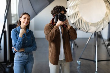 Anı yakalıyorum. Stüdyoda güvenilir asistanıyla fotoğraf çekimi yapan bir erkek fotoğrafçı. Stüdyo ışığı açıkken fotoğraf çeken fotoğrafçı..