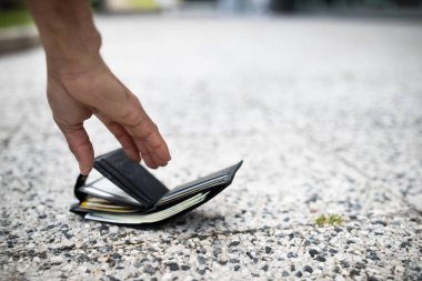 Siyah adamın para dolu cüzdanı alıp şehir sokağından seçici odak noktası, boş alan seçerken yakın plan görüntüsü. Kayıp para kavramı