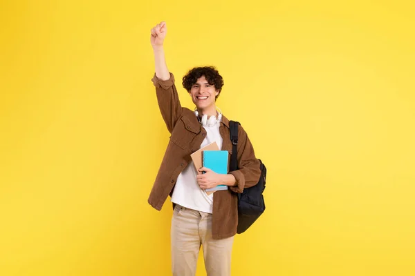 学ぶことを熱望している 熱意と自信を持って腕を上げる幸せな学生の男は 黄色のスタジオの背景に立って質問し 洞察を共有する準備ができて — ストック写真