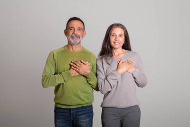 Mutlu Kafkasyalı yaşlı adam ve bayan göğüs göğüse, gri stüdyo arka planında minnettarlık jesti, kopyalama alanı. Teşekkürler, aşk, ilişkiler ve insan duyguları, iyi haber.