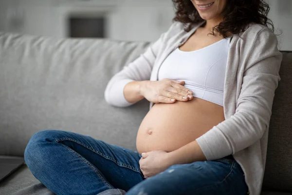 Doğum Bakımı Gülümseyen Karnına Dokunan Hamile Bir Kadın Evde Koltukta — Stok fotoğraf