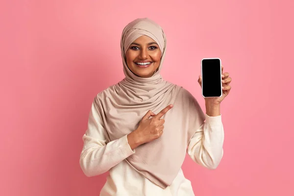 Smiling Muslim Lady Pointing Blank Smartphone Black Screen Her Hand — Stok Foto
