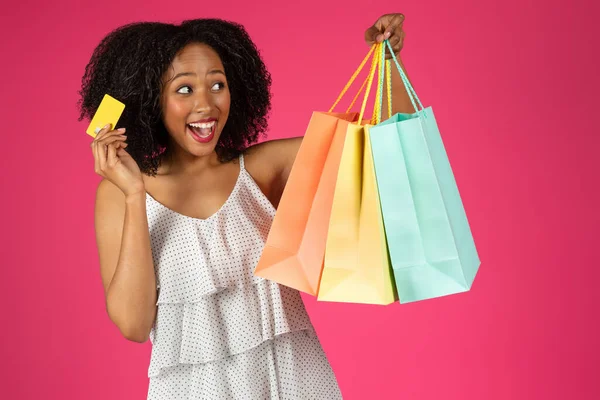 クレジットカードを持つ陽気な驚きの若い黒の巻き女性は ピンクの背景 スタジオに隔離されたショッピングをお楽しみください Shopaholic販売 オファー キャッシュバックと金融 — ストック写真