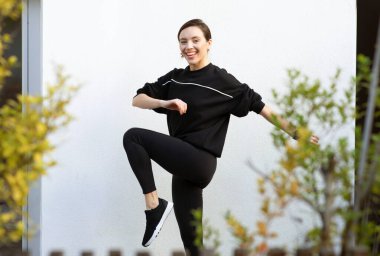 Binlerce yıllık Avrupalı bayan sporcu şehirde ve dışarıda koşmak için esneme ve ısınma egzersizleri yapıyor. Kilo kaybı ve aktif yaşam tarzı, spor ve pilates eğitimi, vücut bakımı