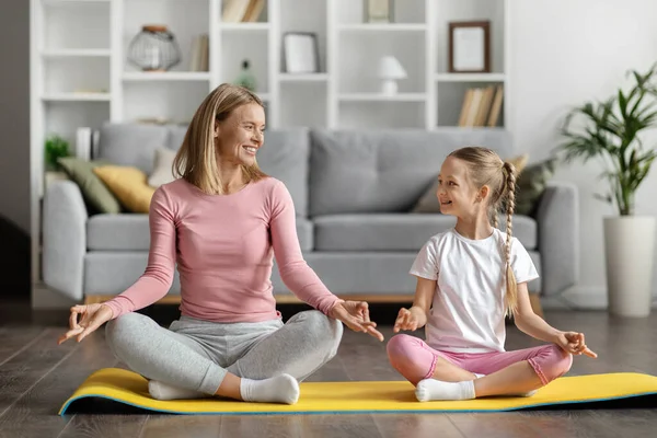 Happy Mother Cute Little Daughter Meditating Together Home Sporty Mom — Stock Photo, Image