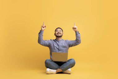 Şuna bak. Sırıtkan Asyalı adam dizüstü bilgisayarla oturmuş, kafasının üstündeki fotokopi odasına işaret ediyor sarı arka planda, neşeli bir milenyum erkeği mesajınız ya da tasarımınız için boş yer gösteriyor.