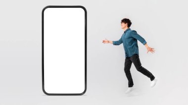 Büyük cep telefonuna boş ekranla bakan neşeli adam, Beyaz Stüdyo Arkaplanında Yeni Gadget 'lar ve Yenilikçi Uygulamalar pozları hayal ediyor. Teknoloji ve Sosyal Medya. Mockup, Panorama