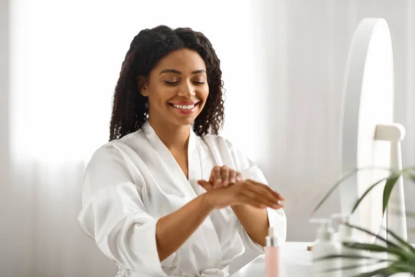 Mujer Afroamericana Sonriente Usando Crema Hidratante Para Las Manos Casa — Foto de Stock