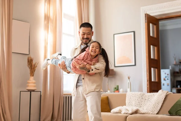 パパと遊べ 幸せな中国人の父を保持赤ちゃんの娘は遊び 一緒に楽しみを持っています 自宅で現代のリビングルームに立って 喜びの結合レジャーコンセプト 選択的フォーカス — ストック写真
