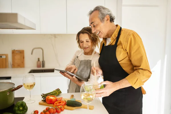 Glada Äldre Par Matlagning Och Använda Digital Tablett Letar Efter — Stockfoto