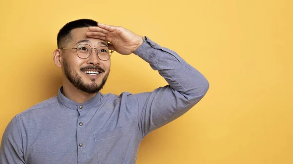 Sorrindo Asiático Homem Mantendo Mão Perto Testa Olhando Fora Para — Fotografia de Stock