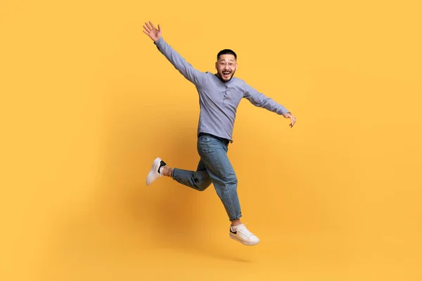 Glad Upphetsad Asiatisk Man Hoppar Luften Gul Bakgrund Rörelse Skott — Stockfoto