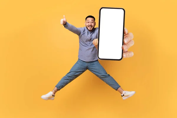 Bra Erbjudande Glad Asiatisk Man Hoppar Med Big Blank Smartphone — Stockfoto