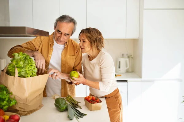 Oudere Echtgenoten Uitpakken Papieren Zak Met Verse Groenten Fruit Keuken — Stockfoto