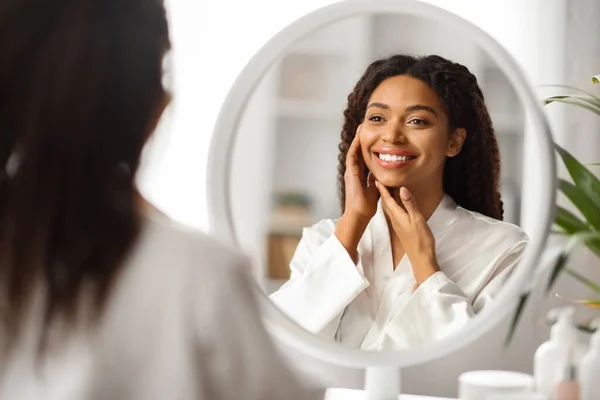 恐怖概念 美丽的年轻黑人女人照镜子 爱抚自己的脸 迷人的非洲裔美国女性享受美容美发后柔滑的肌肤 有选择性的关注 — 图库照片