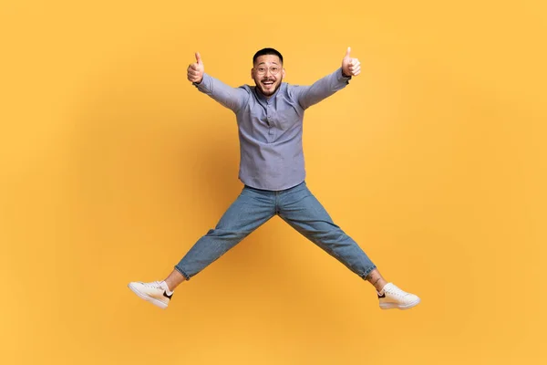 Glada Unga Asiatiska Mannen Hoppar Luften Och Visar Tummen Upp — Stockfoto
