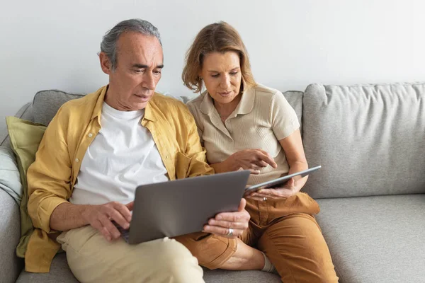 Starší Běloši Používají Notebook Digitální Tablet Sedí Doma Gauči Učí — Stock fotografie