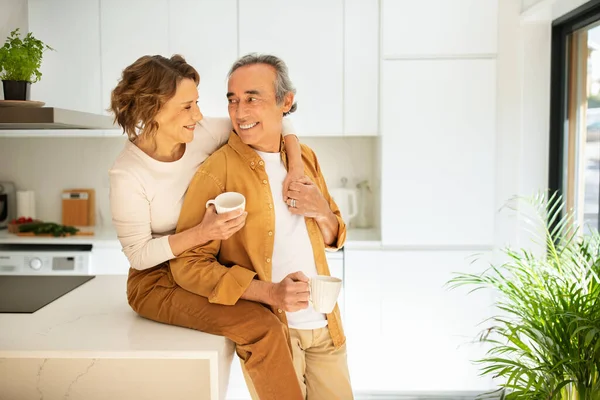 Yaşlı Çifti Seven Sabah Kahvesini Içen Mutfak Masasında Oturan Kocasını — Stok fotoğraf