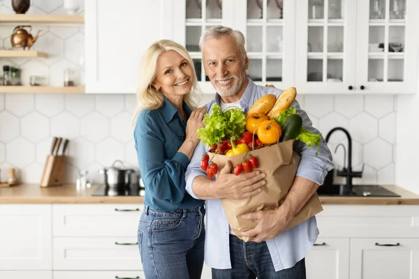 Glückliches Seniorenpaar Posiert Mit Einkaufstasche Der Küche Ältere Ehepartner Ruhestand — Stockfoto
