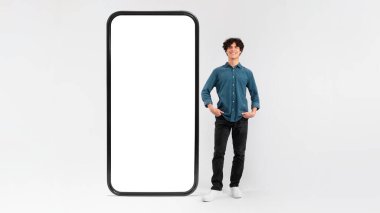 İş Başvurusu. Uygulama reklamı için boş ekranı olan ve Beyaz Stüdyo Arkaplanında Poz Veren Kendine güvenen Genç Adam. Mockup, Panorama