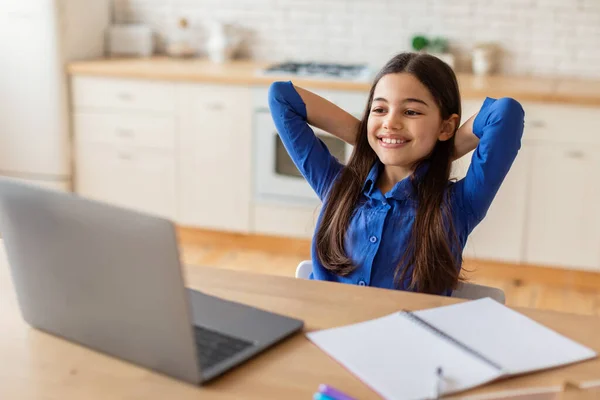 成功的电子学习 十几岁以下的女孩坐在笔记本电脑前 手牵着手坐在后头 在离家很远的课堂上放松一下 喜欢在线学习的小女孩坐在桌旁 — 图库照片
